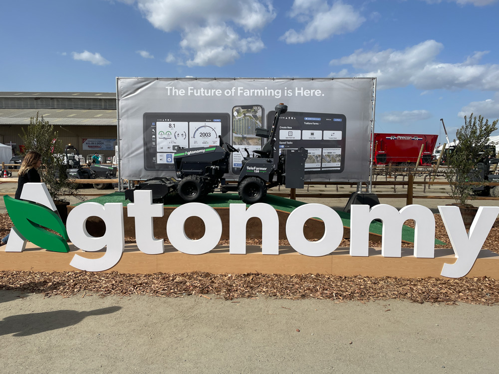 the agtonomy reference tractor sits behind the agtonomy name at the booth.