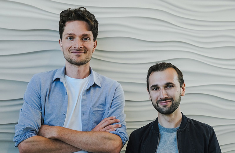 Roboto AI founders against a white wall textured wall. 